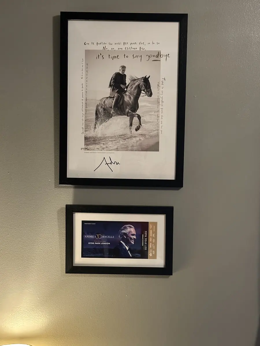 Two black-framed pieces stacked on a wall, a signed photograph above a small portrait
